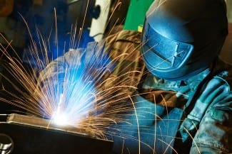 welder working with electrode at semi-automatic arc welding in m
