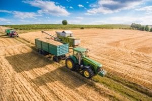 combine-harvester-pouring-grain-into-trailer-towed-by-tractor-picjumbo-com