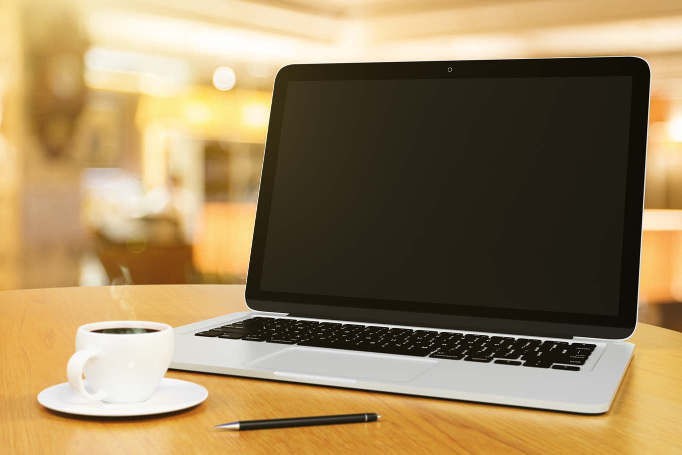 laptop with blank screen on a wooden table with cup of coffee and pen